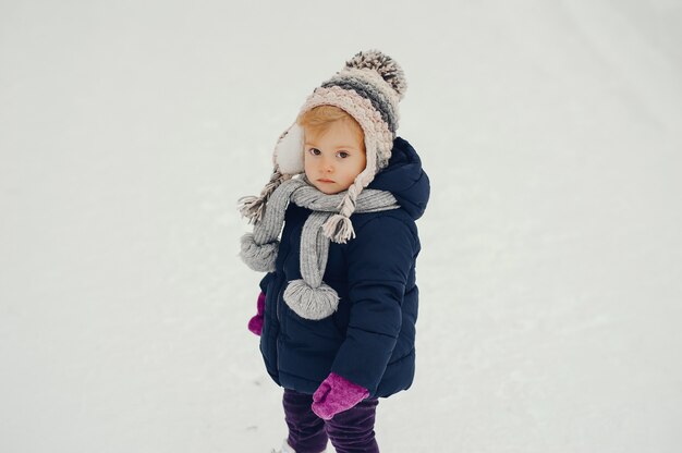 Niña linda en el parque de invierno