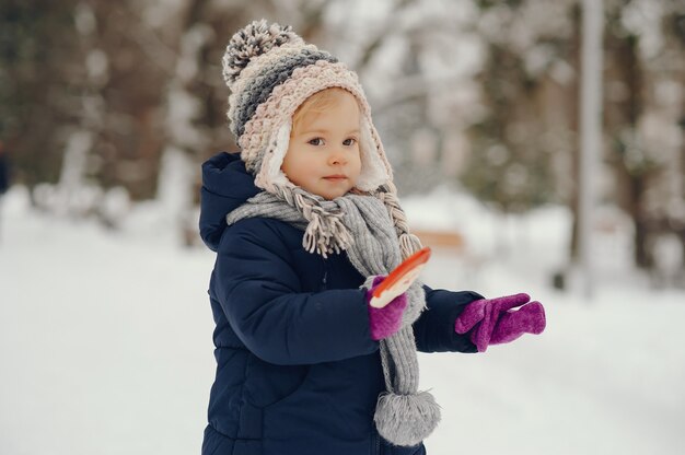 Niña linda en el parque de invierno