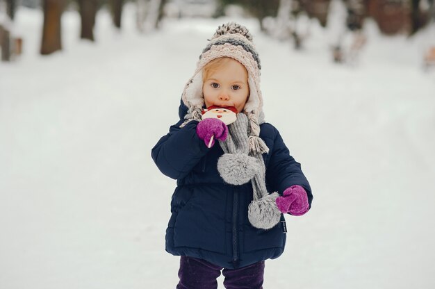 Niña linda en el parque de invierno