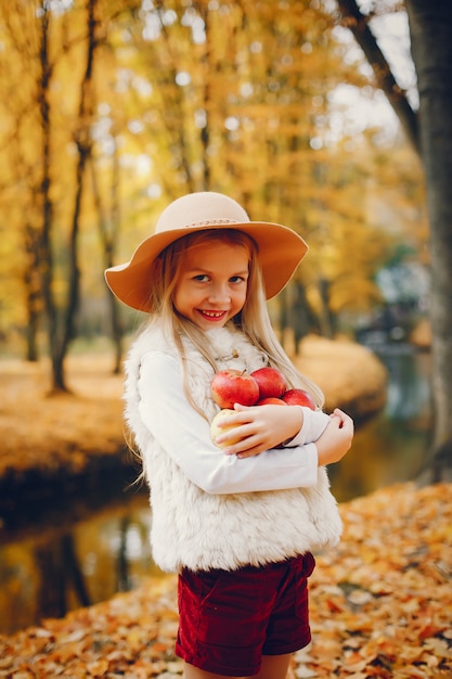 Niña linda en un parque de otoño