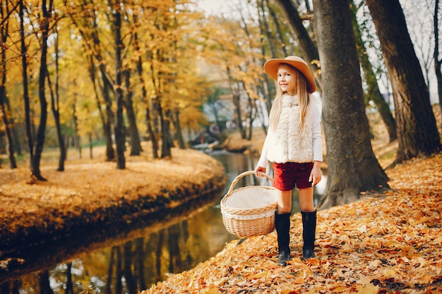 Niña linda en un parque de otoño