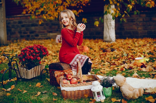 Niña linda en un parque de otoño