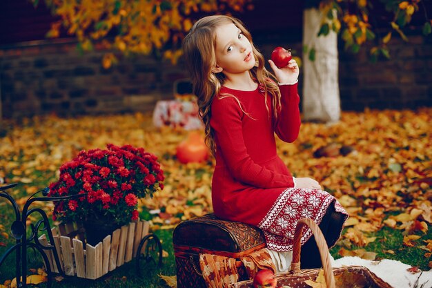 Niña linda en un parque de otoño