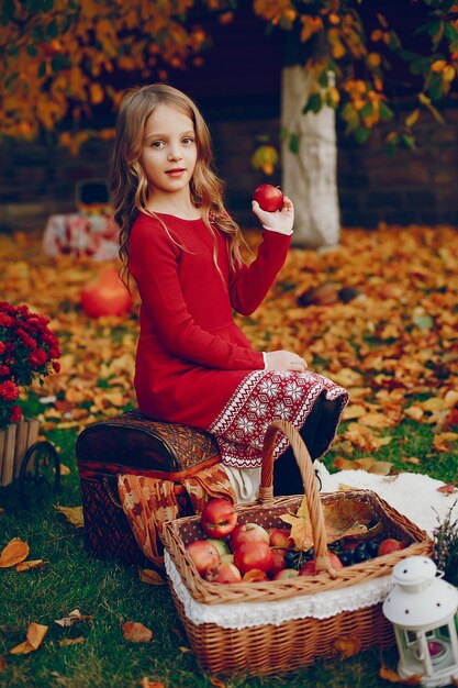 Niña linda en un parque de otoño