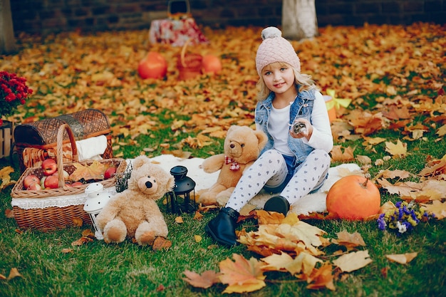 Niña linda en un parque de otoño