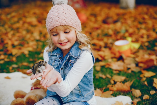 Niña linda en un parque de otoño