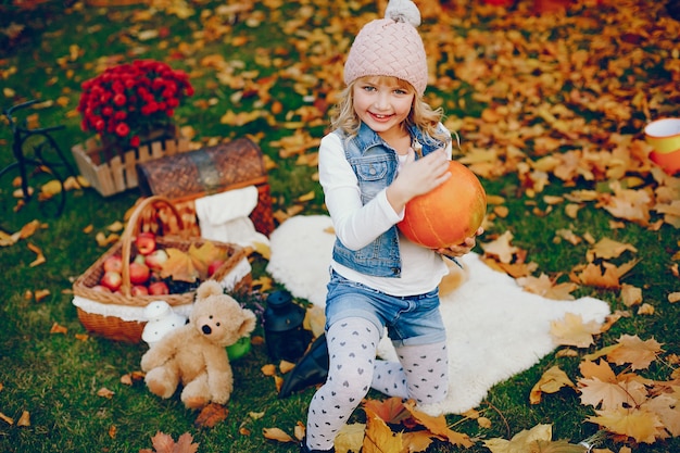 Niña linda en un parque de otoño