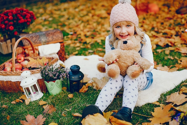 Niña linda en un parque de otoño