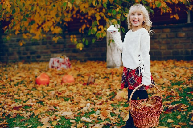 Niña linda en un parque de otoño