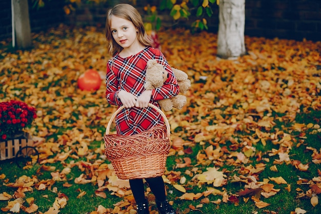 Niña linda en un parque de otoño