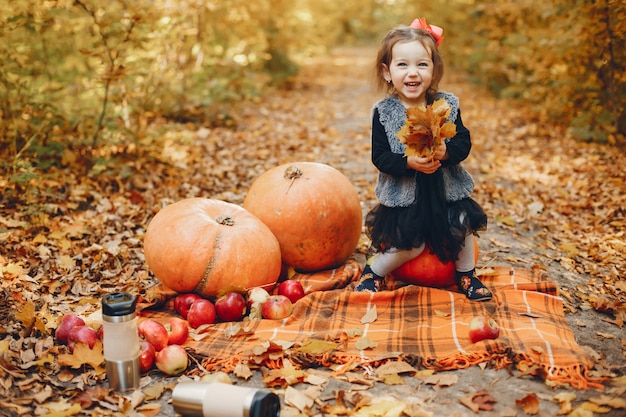 Niña linda en un parque de otoño