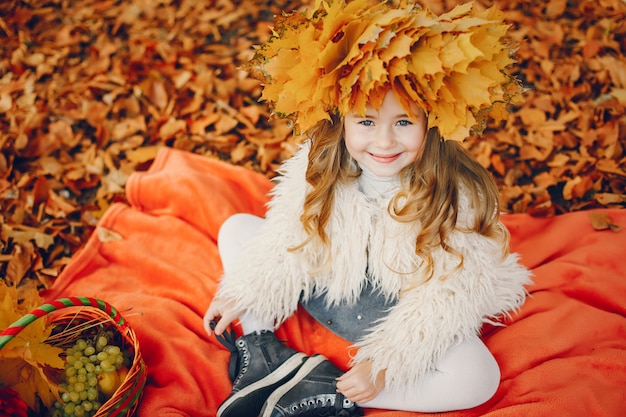 Niña linda en un parque de otoño