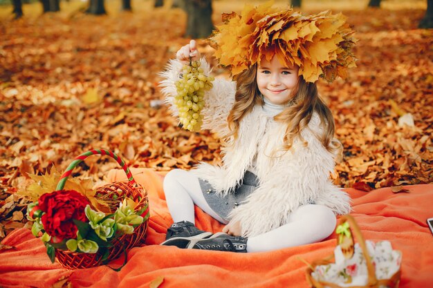 Niña linda en un parque de otoño