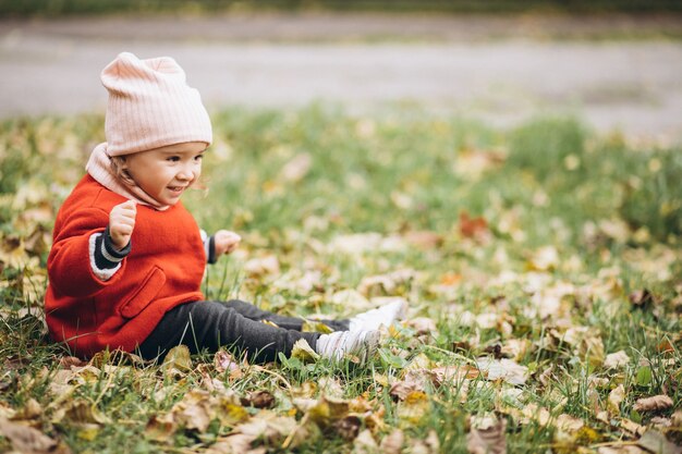 Niña linda en un parque de otoño