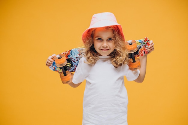 Foto gratuita niña linda con patineta aislada en estudio