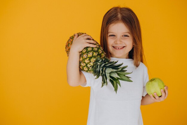 Niña linda con piña y manzana