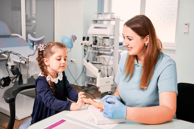 Niña linda que estudia el sistema reproductivo femenino con el doctor