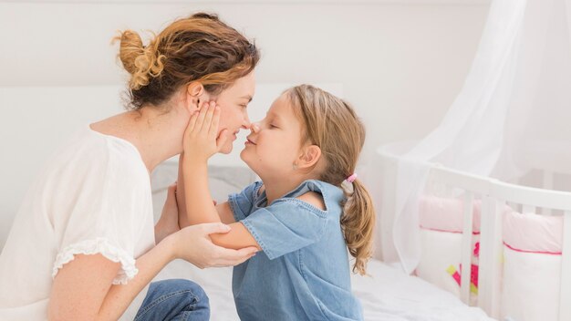 Niña linda que juega con la madre en casa