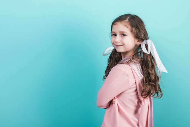 Niña linda que sonríe en fondo azul