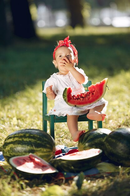 Niña linda con sandías en un parque