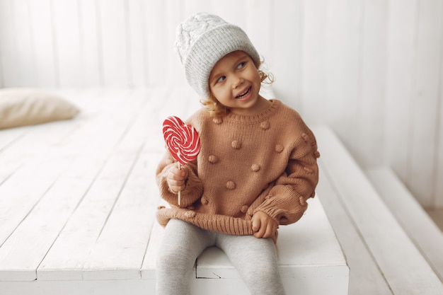 Niña linda sentada y comiendo dulces