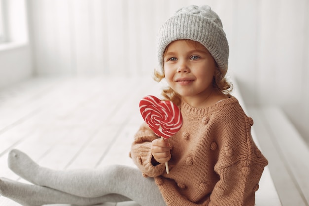 Foto gratuita niña linda sentada y comiendo dulces