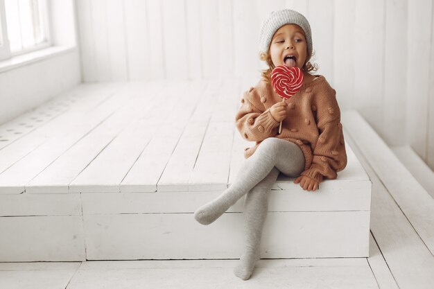 Niña linda sentada y comiendo dulces