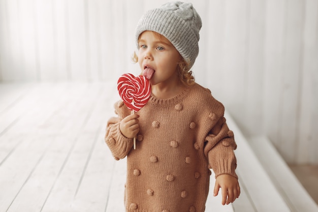 Foto gratuita niña linda sentada y comiendo dulces