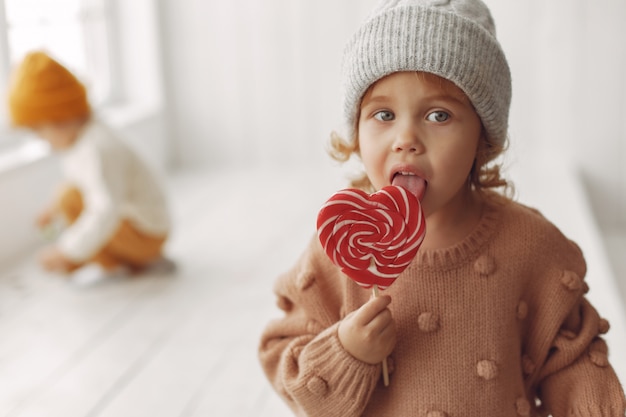 Foto gratuita niña linda sentada y comiendo dulces