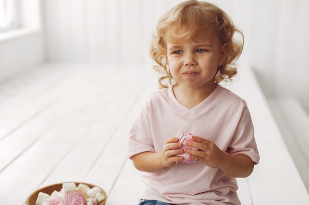 Niña linda sentada y comiendo galletas