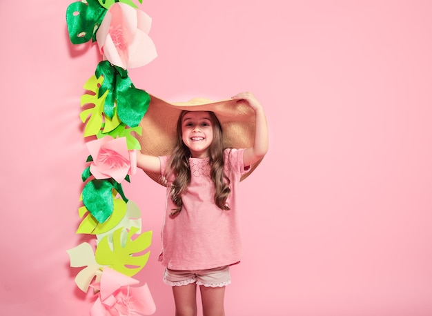 Niña linda con sombrero de verano sobre fondo de color