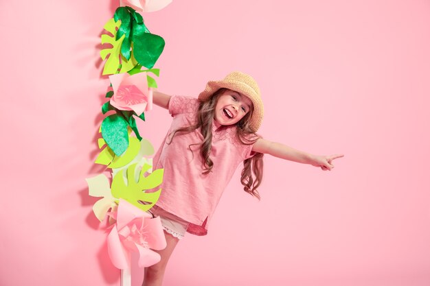 Niña linda con sombrero de verano sobre fondo de color