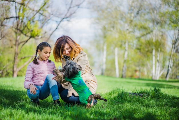 Niña linda con su mascota y su madre sonriente