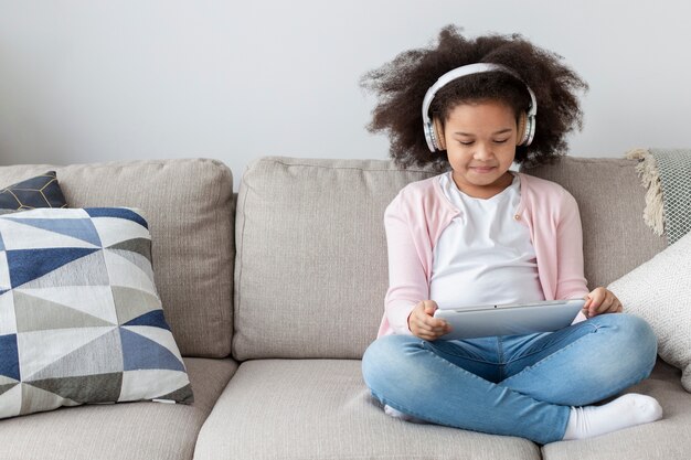 Niña linda viendo dibujos animados en casa