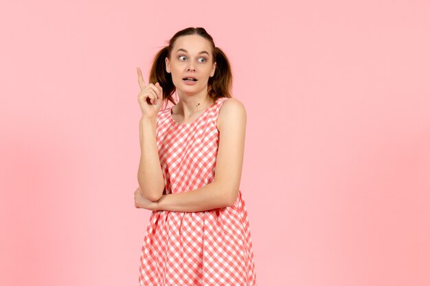 niña con lindo vestido brillante con expresión emocionada en rosa claro