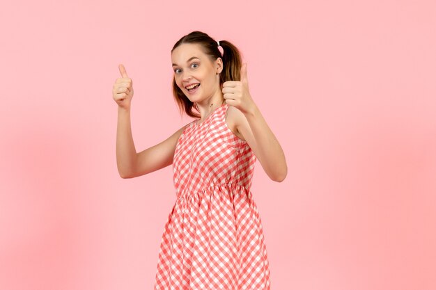 niña en lindo vestido brillante con expresión emocionada en rosa