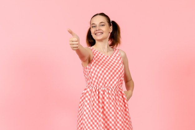 niña en lindo vestido brillante con expresión feliz en rosa