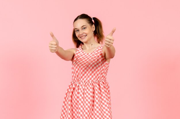 niña en lindo vestido brillante con expresión feliz en rosa