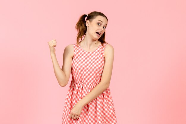 niña en lindo vestido rosa apuntando en rosa