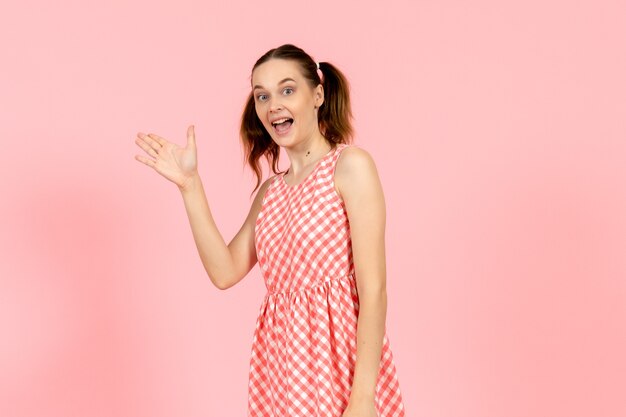 Foto gratuita niña en lindo vestido rosa con cara emocionada en rosa