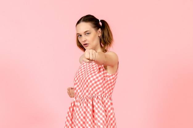 niña en lindo vestido rosa con expresión concentrada en rosa