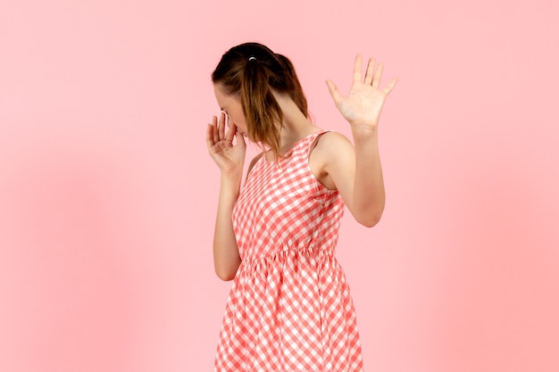 niña en lindo vestido rosa con expresión de disgusto en rosa