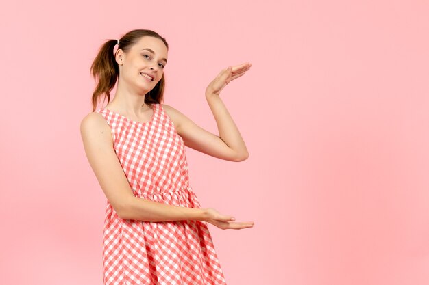 niña en lindo vestido rosa con expresión emocionada en rosa