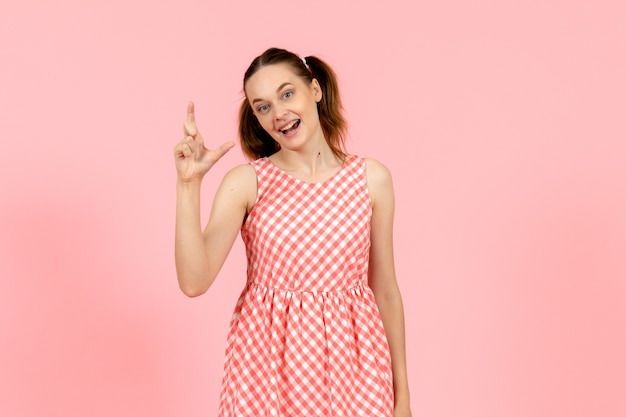 niña en lindo vestido rosa con expresión emocionada en rosa