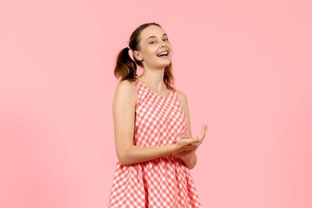 niña en lindo vestido rosa con expresión encantada en rosa