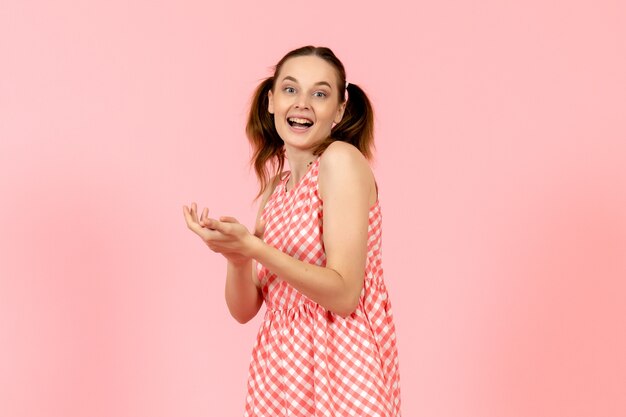 niña en lindo vestido rosa con expresión encantada en rosa