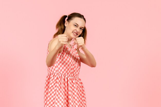 niña en lindo vestido rosa con expresión enojada en rosa