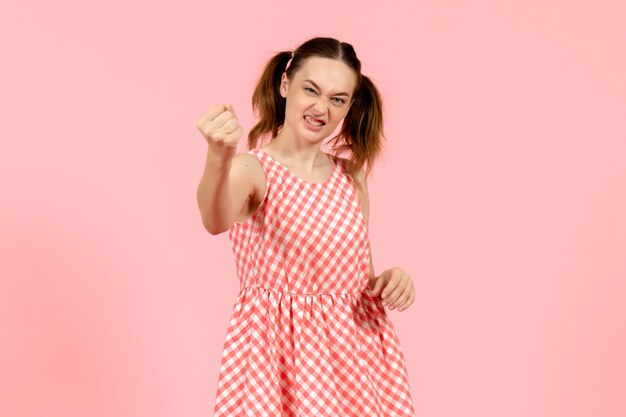 niña en lindo vestido rosa con expresión enojada en rosa