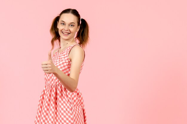 niña en lindo vestido rosa con expresión feliz en rosa