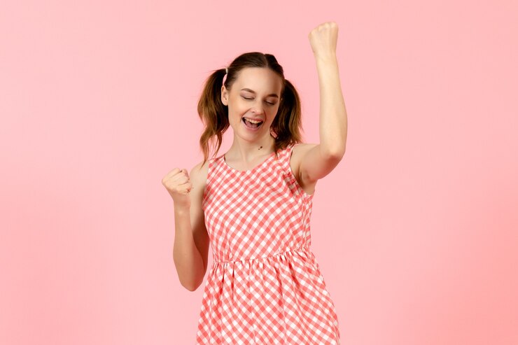 Foto gratuito niña en lindo vestido rosa con expresión de regocijo en rosa